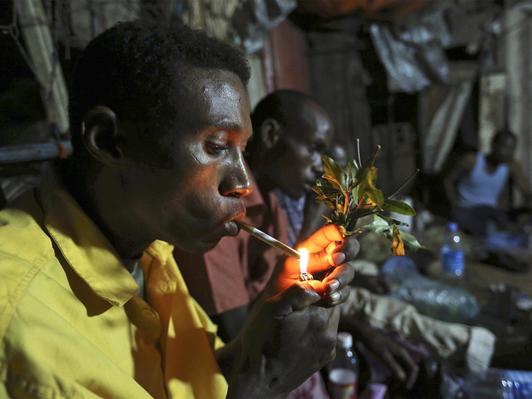 Somali men smoke and chew khat in a market in Mogadishu, where prices have fallen