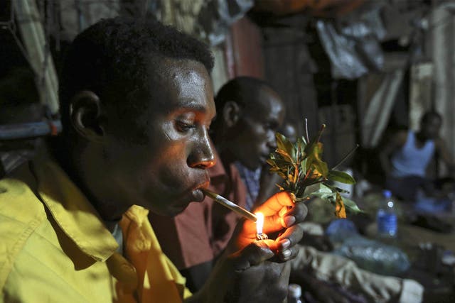 Somali men smoke and chew khat in a market in Mogadishu, where prices have fallen