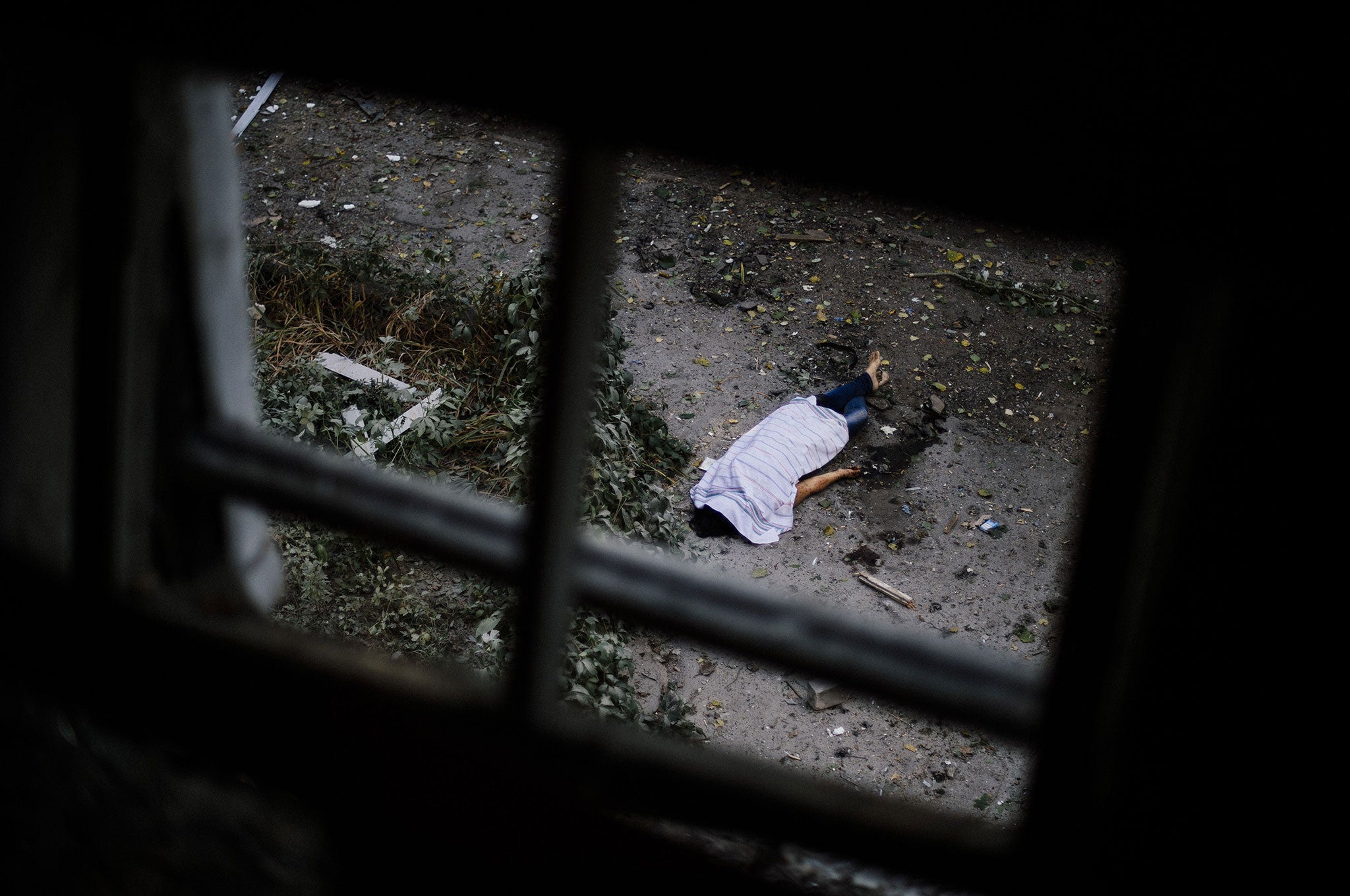 The body of a woman lies on the ground after a shelling in the main separatist stronghold Donetsk. Three bodies were identified by bystanders as members of the same family