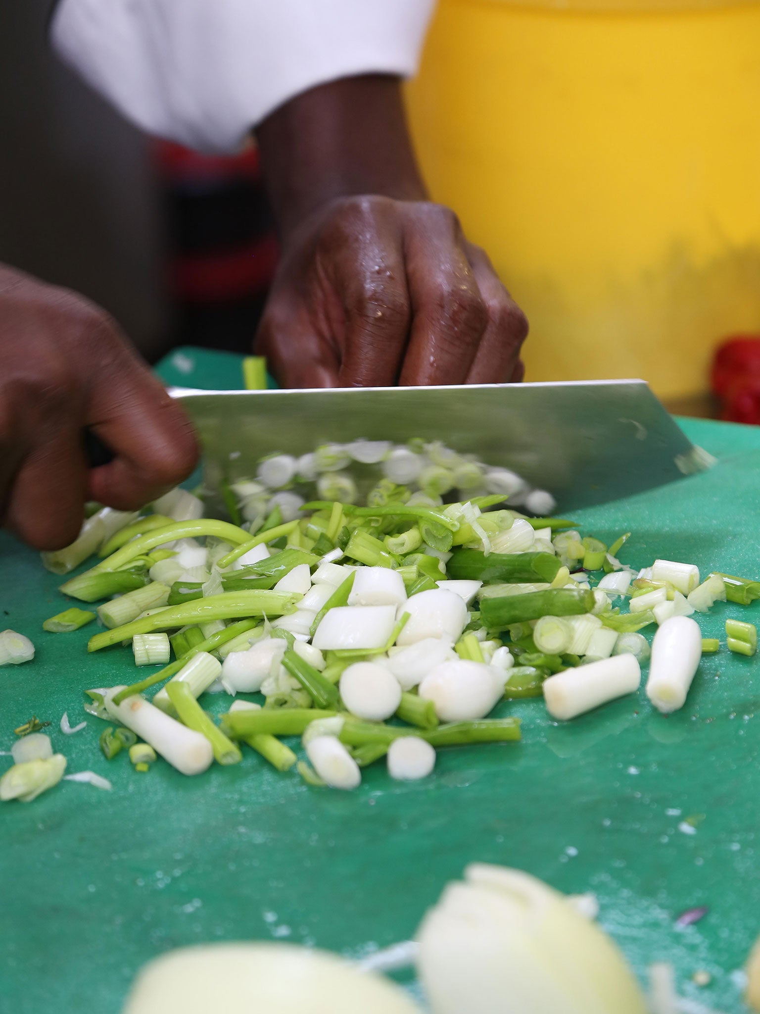 Chef Branatic Neufville chopping spring onions for a jerk marinade