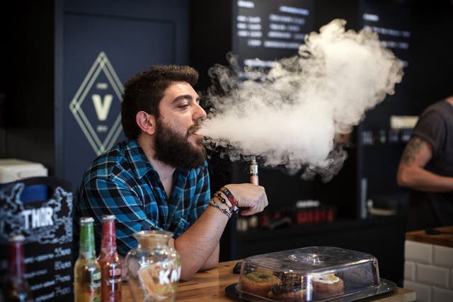 Vape Lab employee Leonardo Verzaro uses an E-Cigarette while working in London. The Department of Health have ruled out the outlawing of 'e-cigs' in enclosed spaces in England, despite calls by the World Health Organisation to do so. WHO have recommended 
