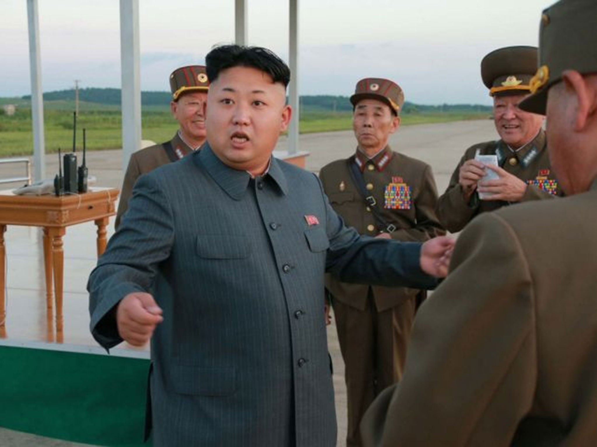 North Korean leader Kim Jong-Un (L) inspects a parachute