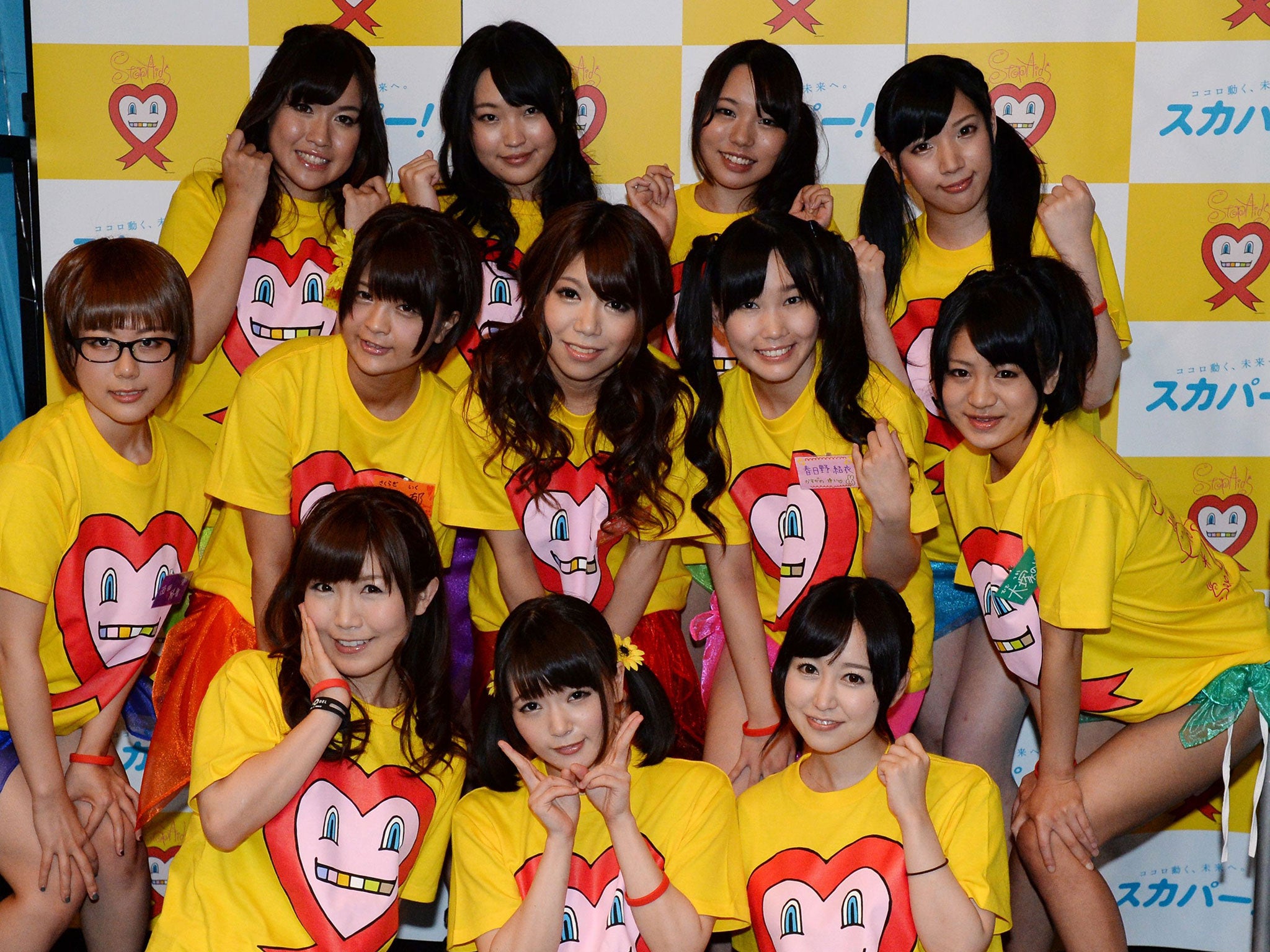 Nine Japanese porn actresses,pose with three supporters in Tokyo on August 30, 2014, as they were preparing to have their breasts squeezed by fans for 24 hours for a charity event loosely translated as "Boob Aid".