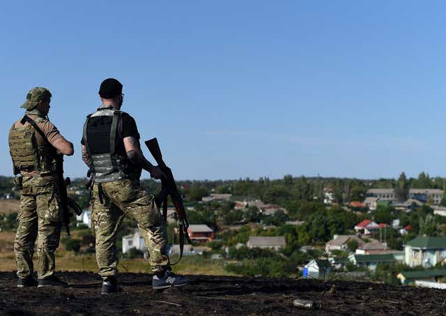 Ukrainian loyalist fighters from the Azov Battalion stand guard on a hill on the outskirts of Mariupol on August 30, 2014