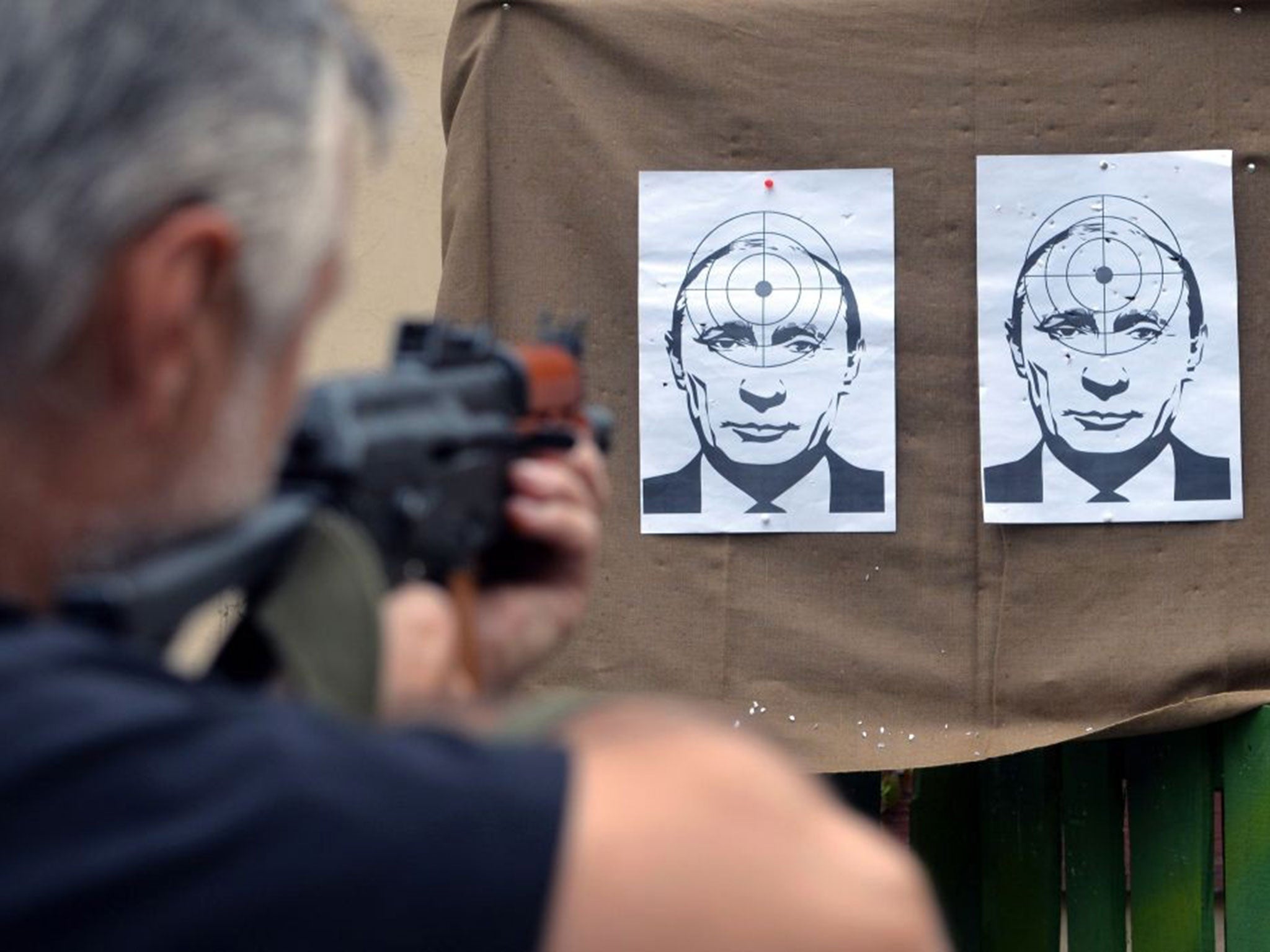 A man shoots at targets depicting a portrait of Russian President Vladimir Putin, in a shooting range in the center of the western Ukrainian city of Lviv