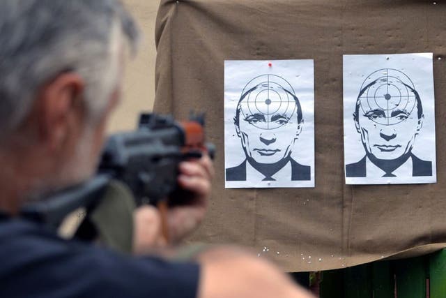 A man shoots at targets depicting a portrait of Russian President Vladimir Putin, in a shooting range in the center of the western Ukrainian city of Lviv