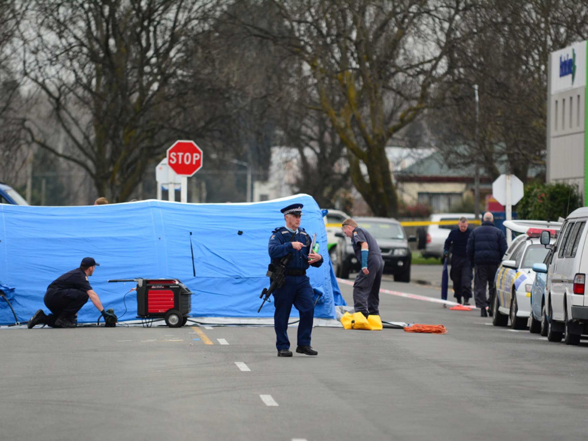 An armed officer stands in front of the crime scene in New Zealand