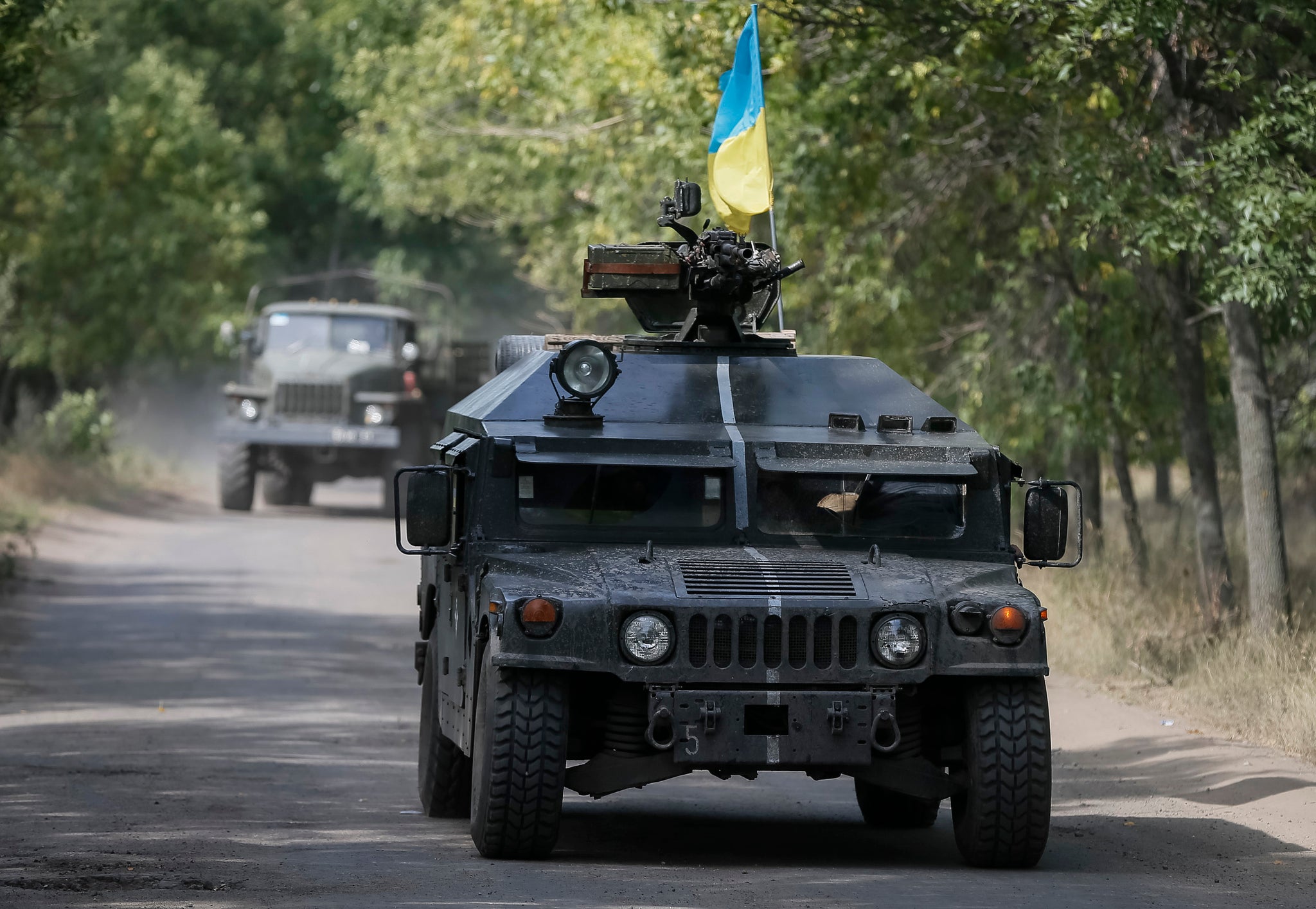 Ukrainian servicemen ride in an armoured vehicle as the country's Defence Minister accuses Russia of starting a 'great war'