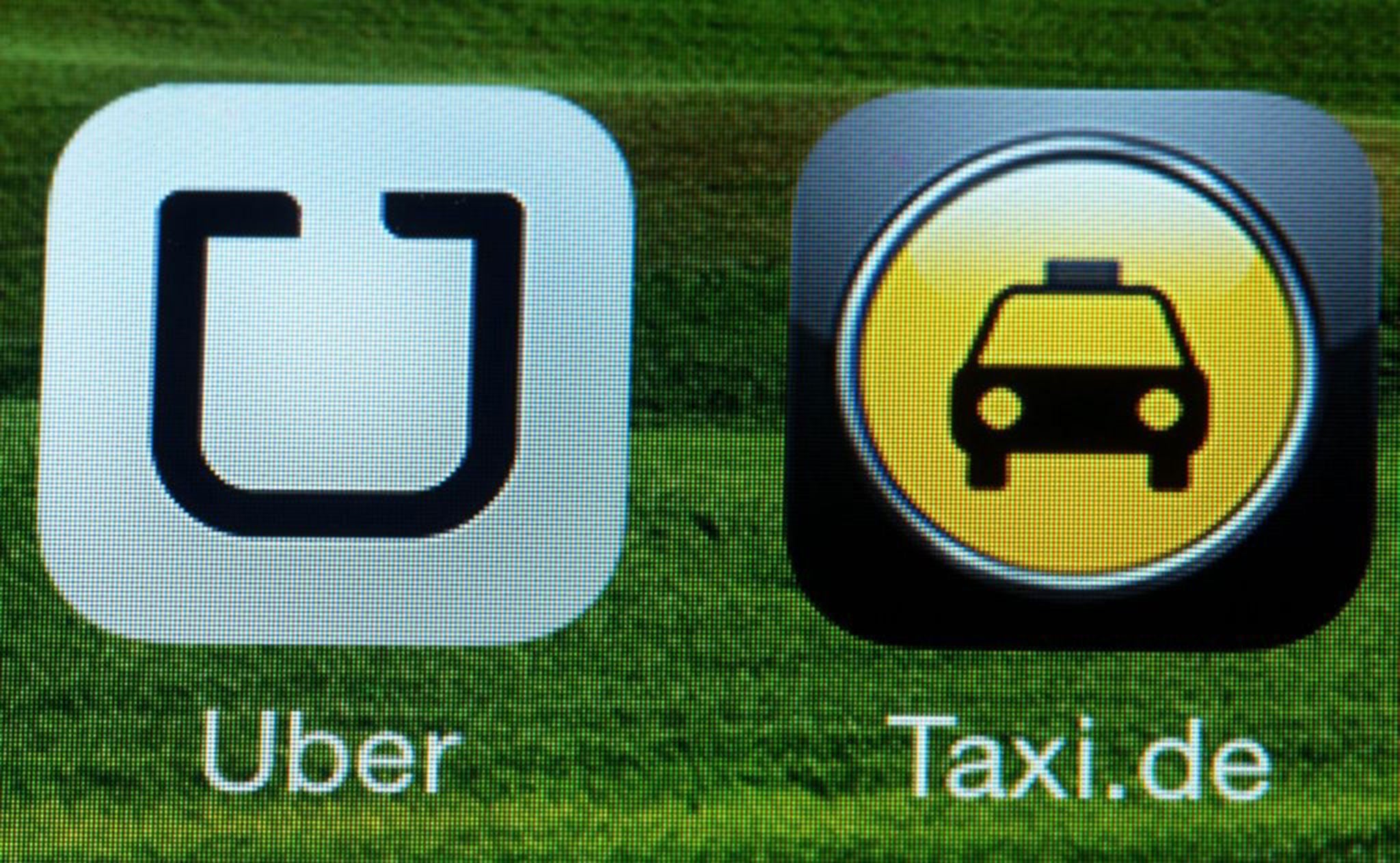 The logo of mobile phone applications Uber (L) and a taxi service (R) are captured on a smartphone in Schwerin, Germany