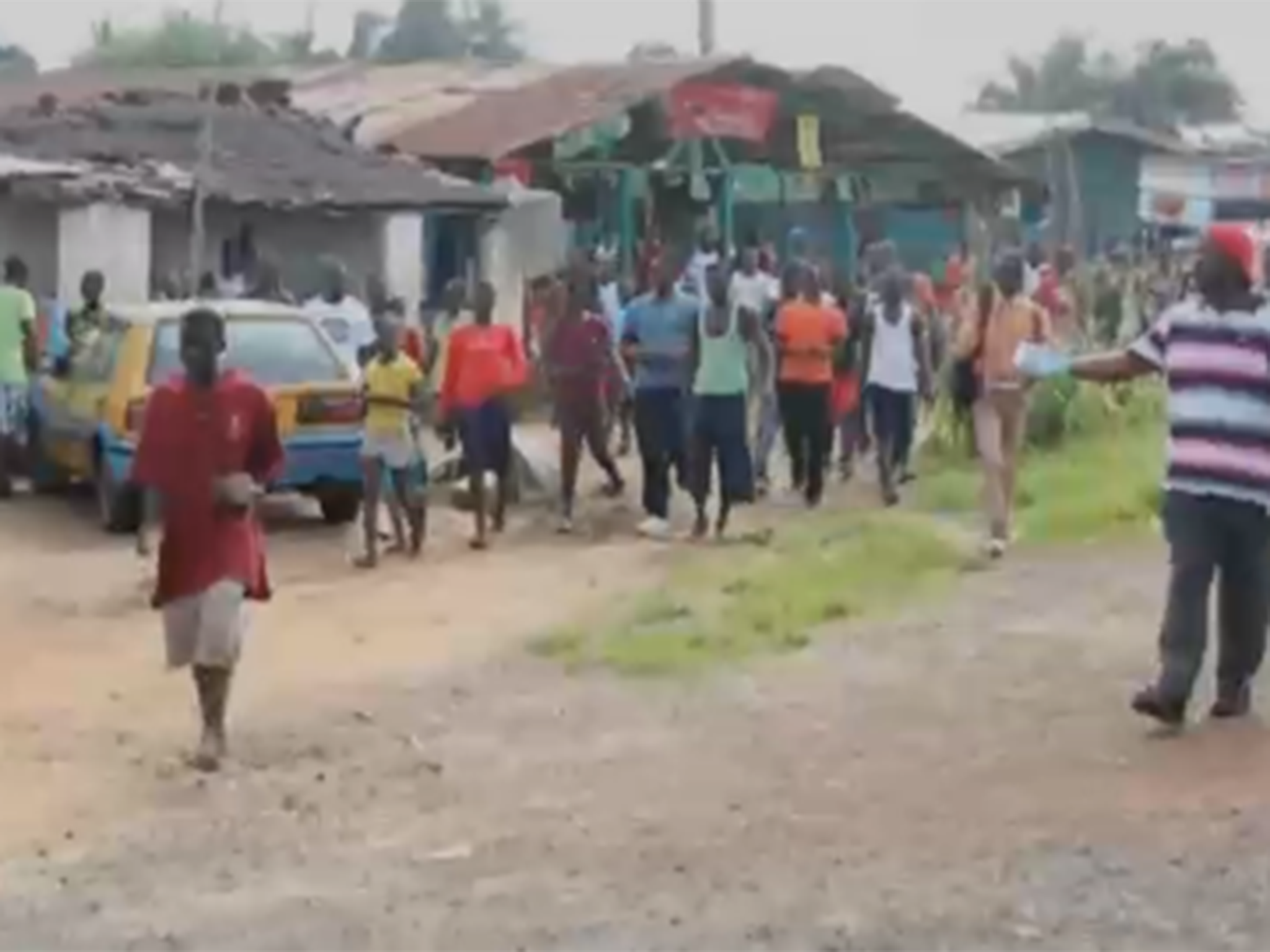 The man in red can be seen wearing a white tag - showing he has tested positive for Ebola