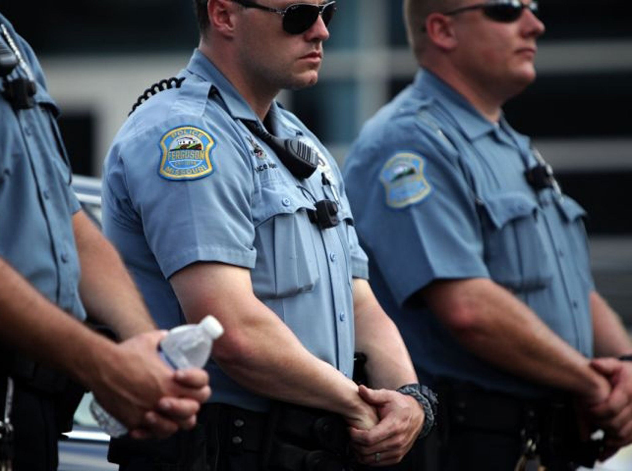 Police officers wear what appear to be body cameras