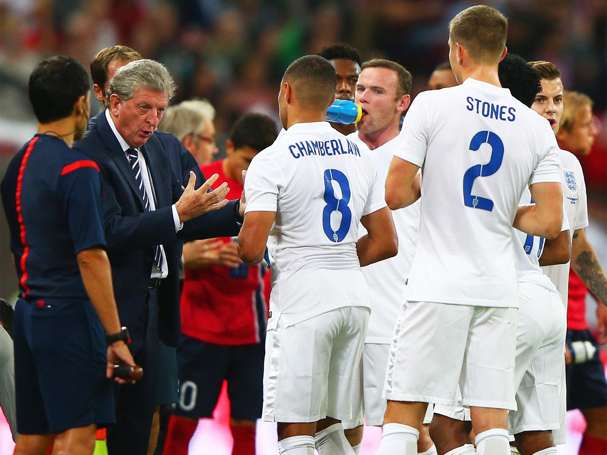 Roy Hodgson speaks to his players during a water break