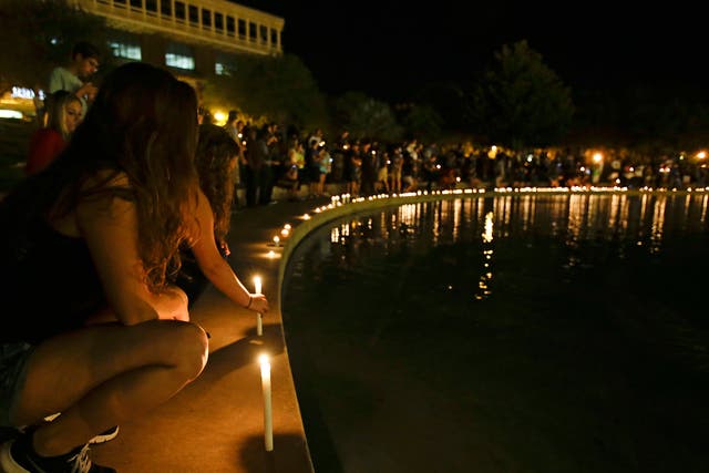 Students and supporters place candles at the edge of a wall surrounding a pond as they take part in a candle light vigil at the University of Central Florida, Wednesday, Sept. 3, 2014, in Orlando, Fla., to honor Steven Sotloff, the second American journal