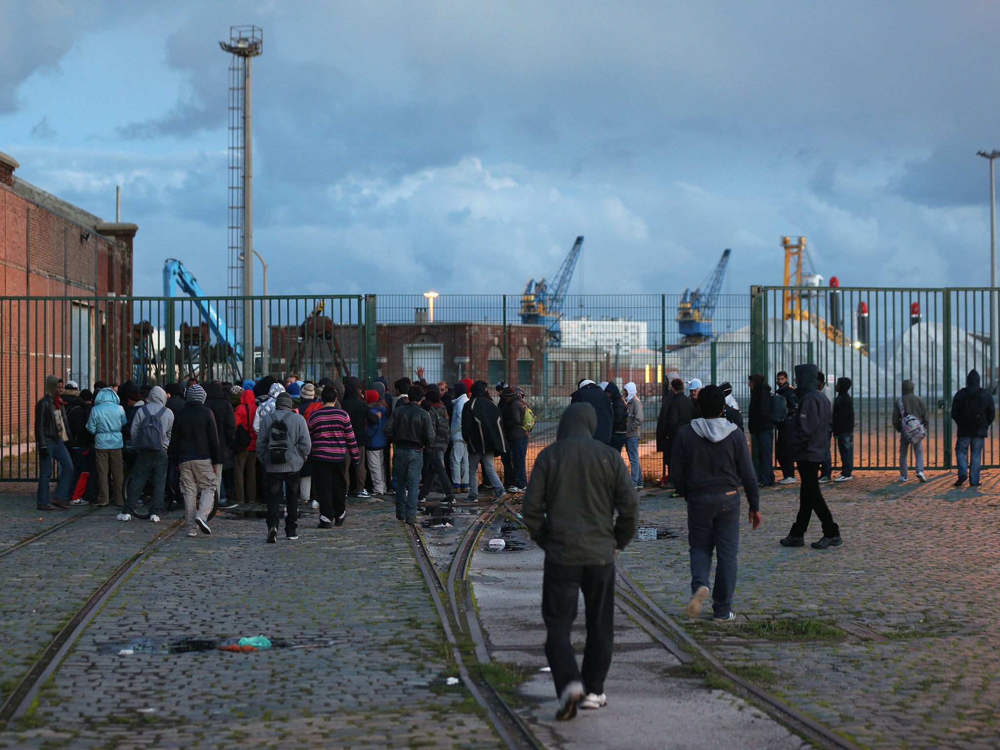 Migrants queue to receive their daily supply of a hot meal in Calais