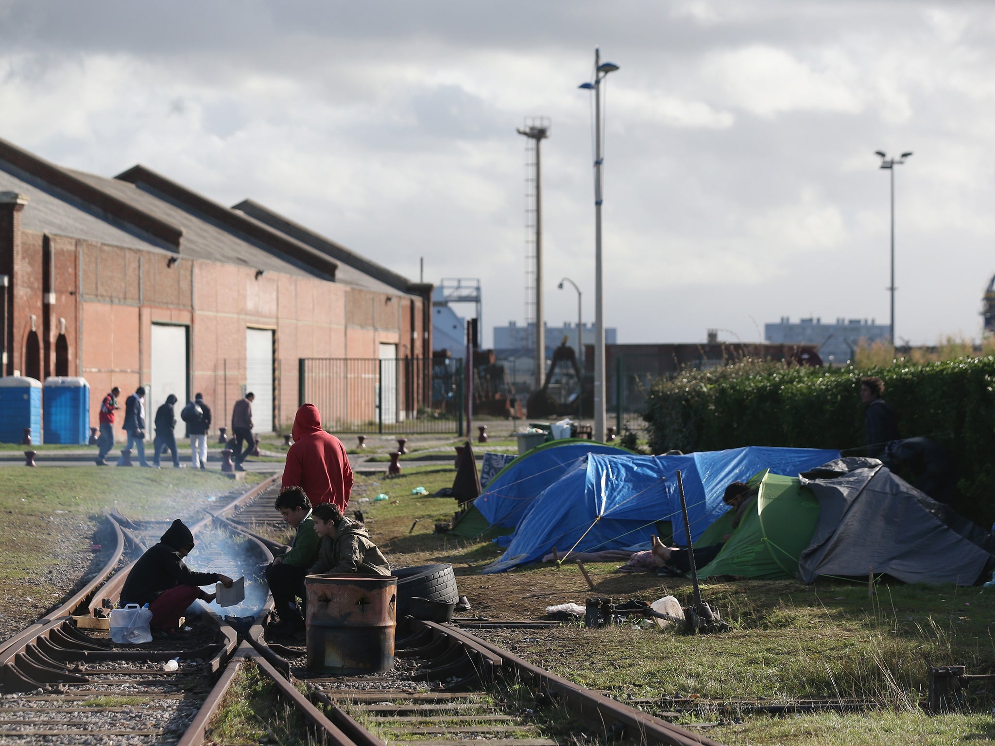 Migrants, mainly of Syrian origin, rest in tents near Calais