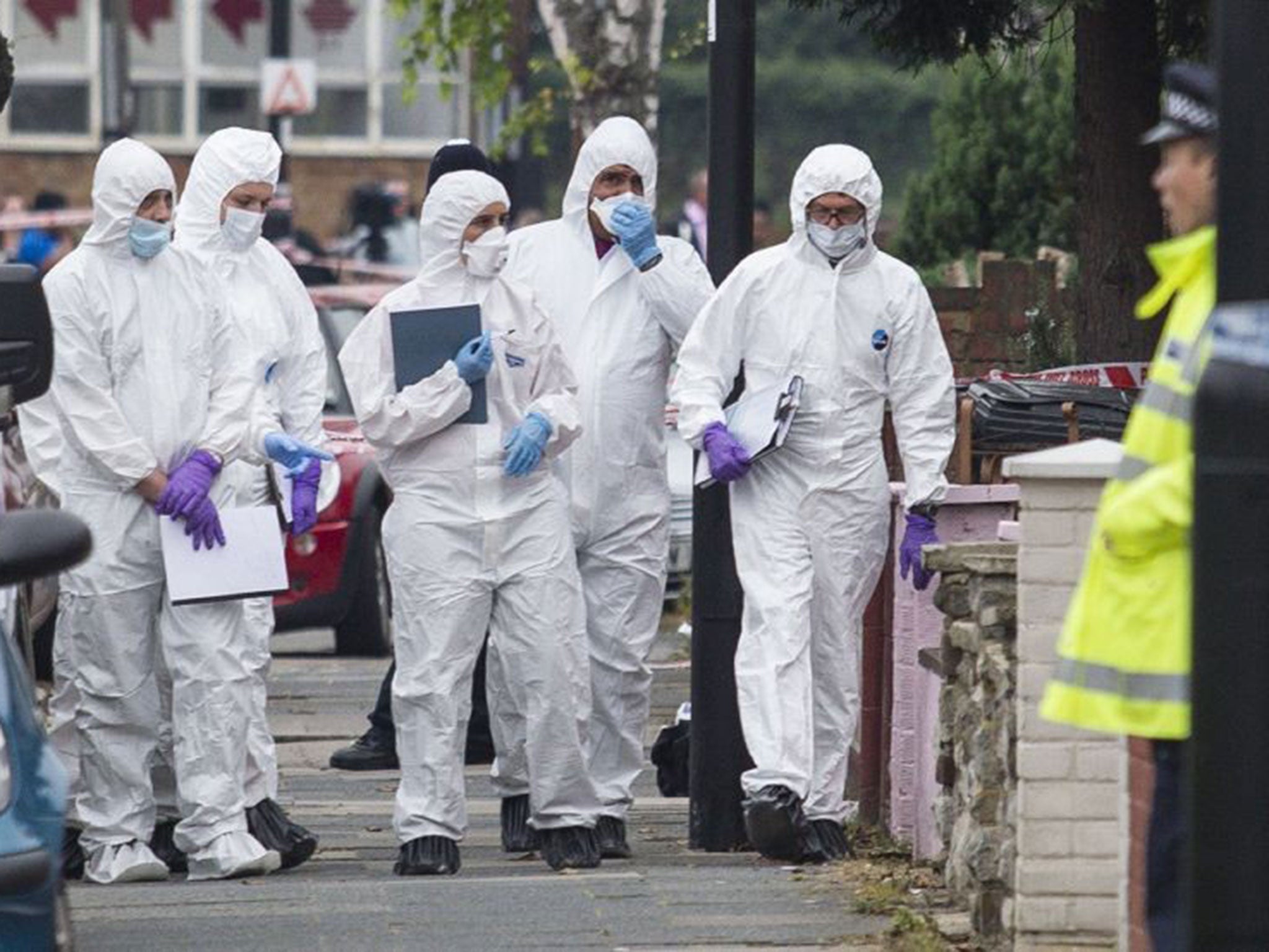 Police forensics personnel examined the garden where the beheading took place