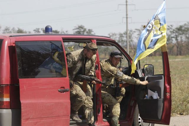 Soldiers of Ukrainian self-defence battalion "Azov" get out of a car as they arrive at a checkpoint in the southern coastal town of Mariupol