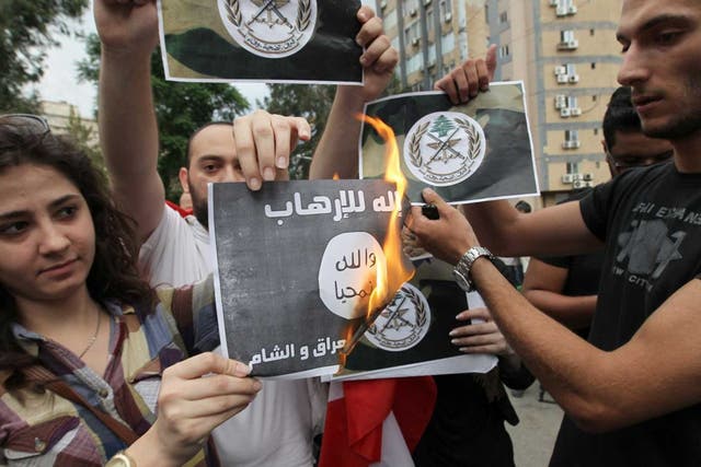 Fired up: Lebanese activists protest by burning paper Islamist flags in Beirut
