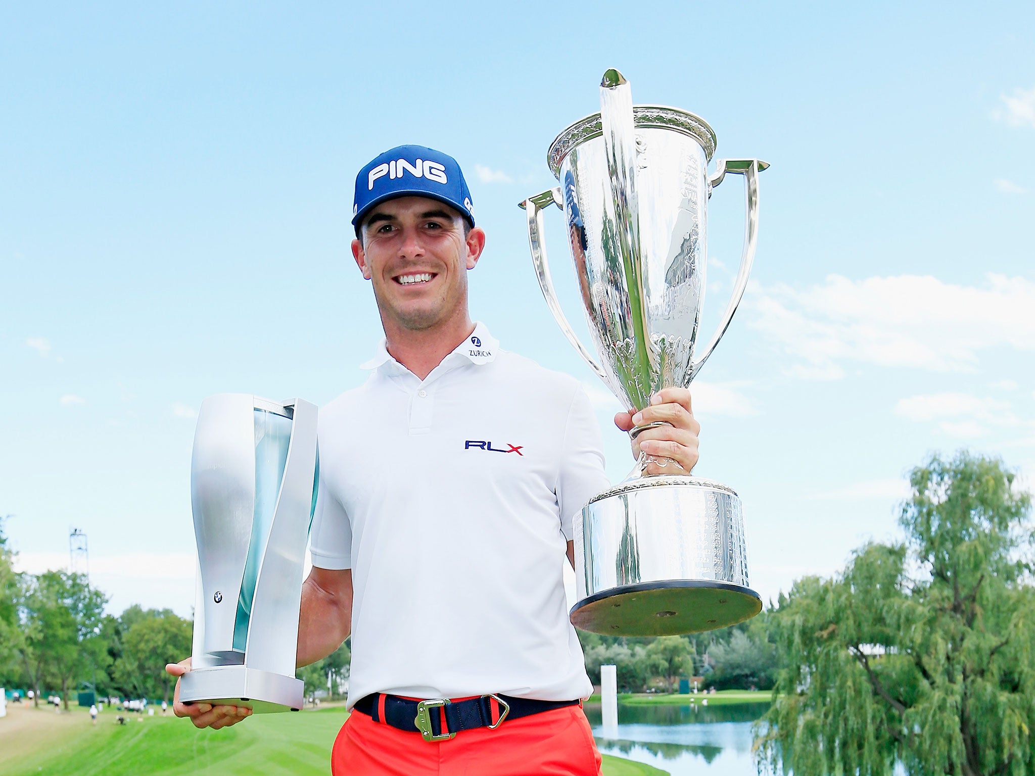 Billy Horschel of the United States poses with the BMW trophy (L) and J.K. Wadley trophy (R)
