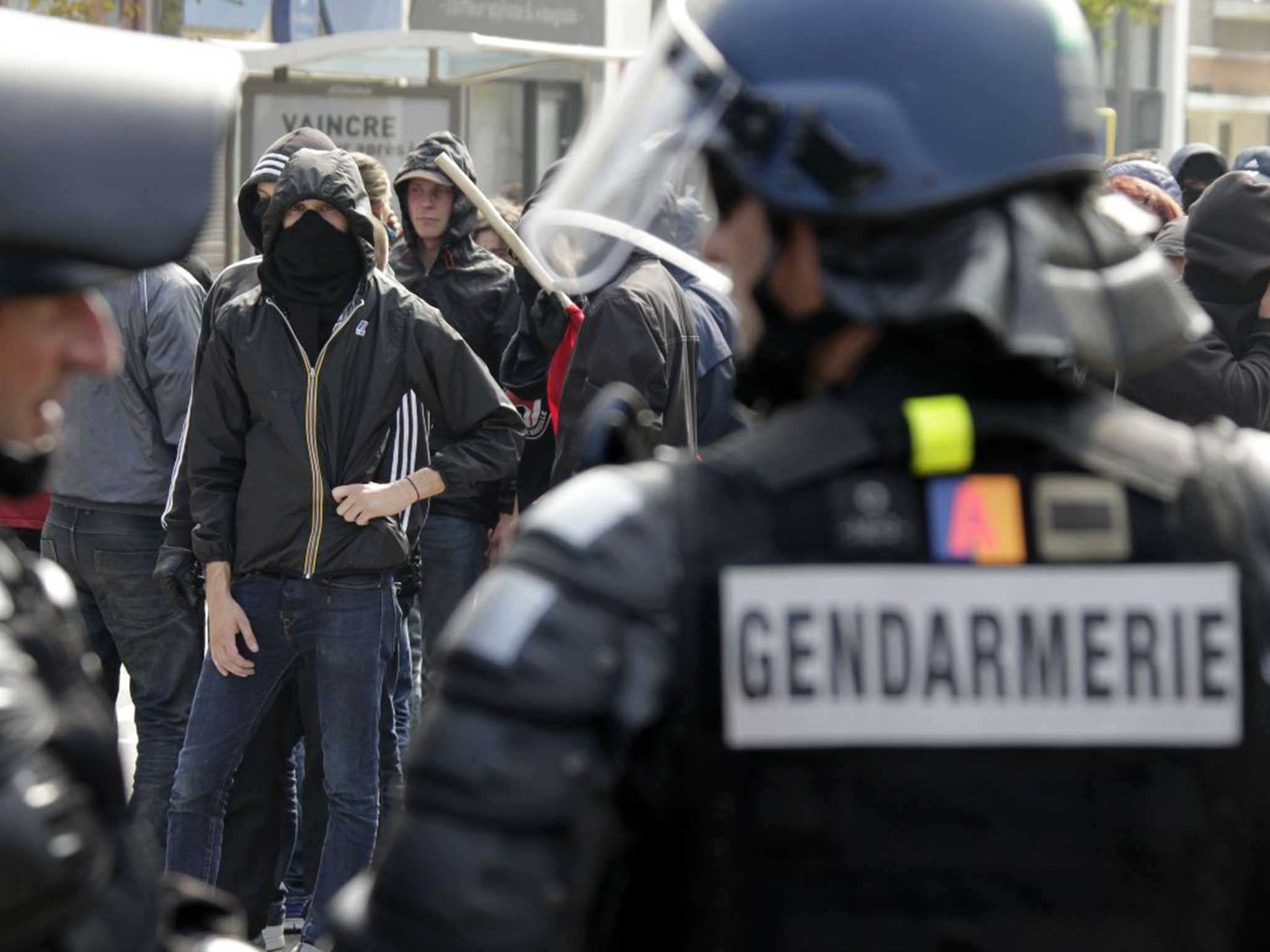 French police and demonstrators eye one another yesterday in Calais