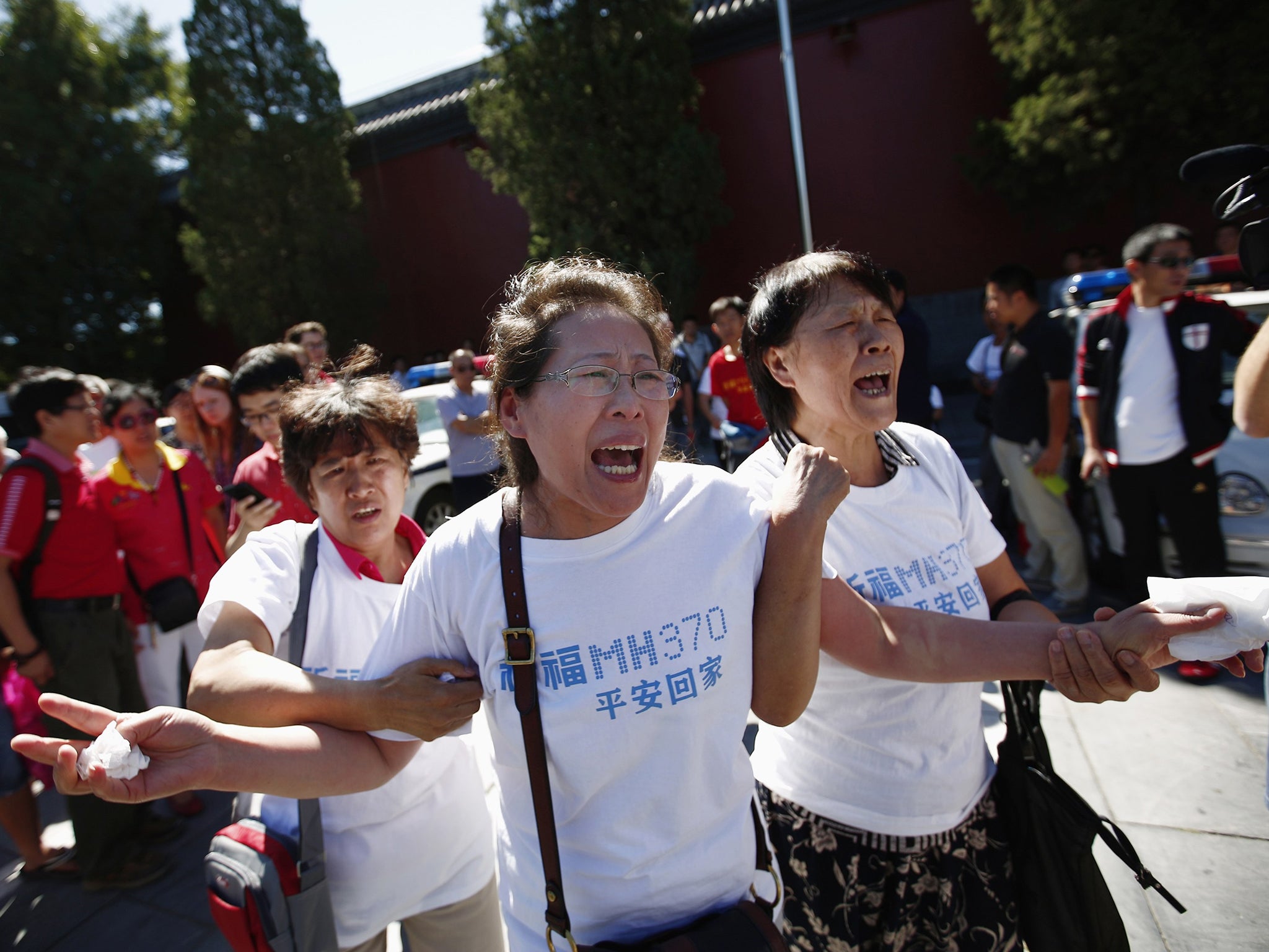 Family members of passengers onboard the missing Malaysia Airlines Flight MH370, cry as they gather to pray Yonghegong Lama Temple in Beijing, on the six-month anniversary of the disappearance of the plane