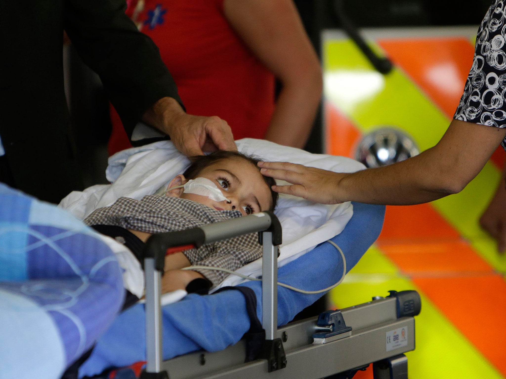 Ashya King, a 5-year-old British boy with a brain tumour, lies on a stretcher as he arrives with his parents at Motol Hospital in Prague