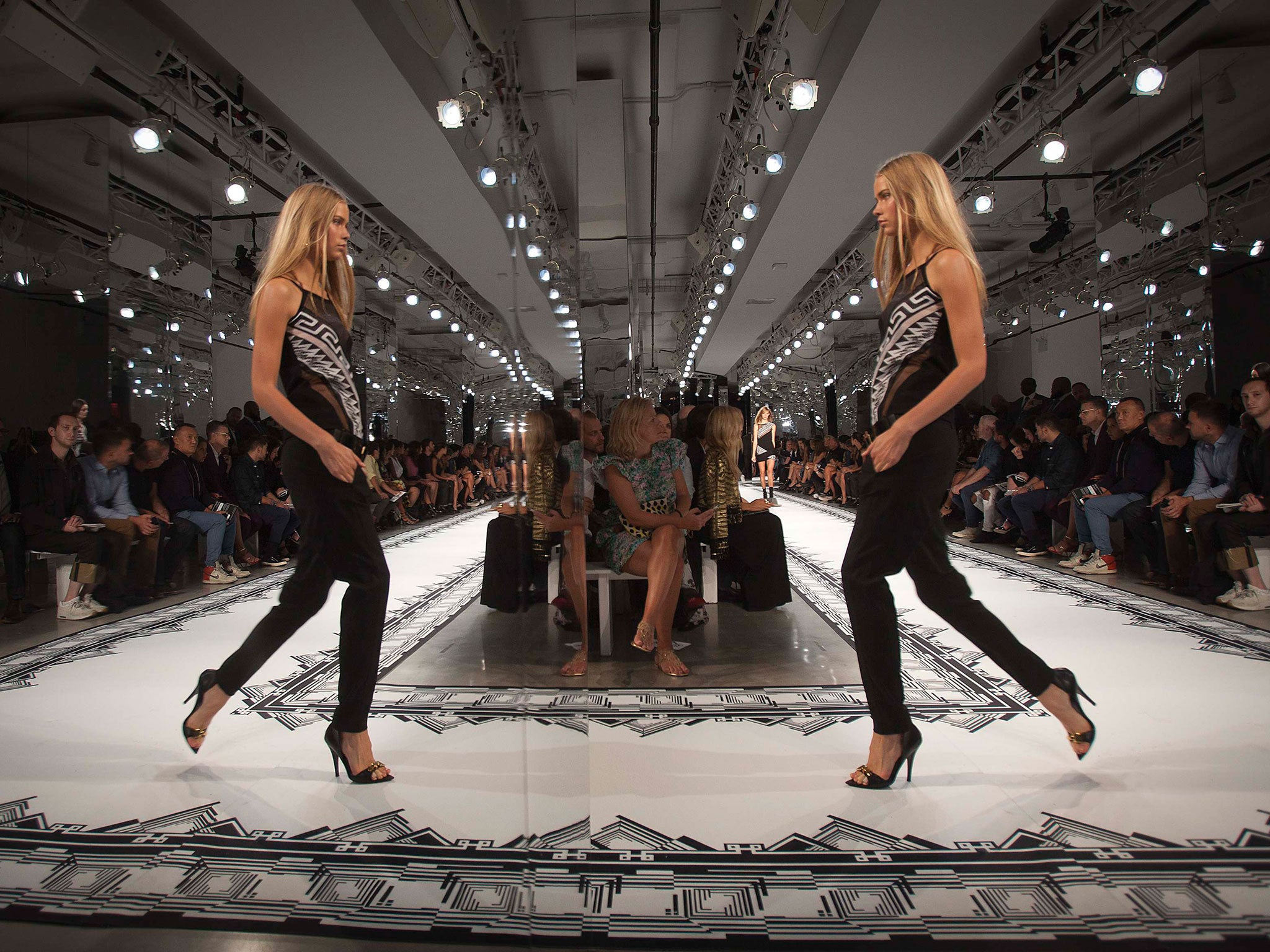 A catwalk model is reflected in a mirror during the Versus Versace show in New York’s Fashion Week