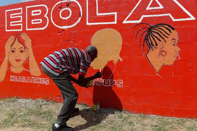 A Liberian man paints on a wall as part of a sensitization programme about the deadly Ebola virus in Monrovia, Liberia. The World Health Organization (WHO) has said the number of deaths from Ebola has risen to 2100 in West Africa with an exponential surge