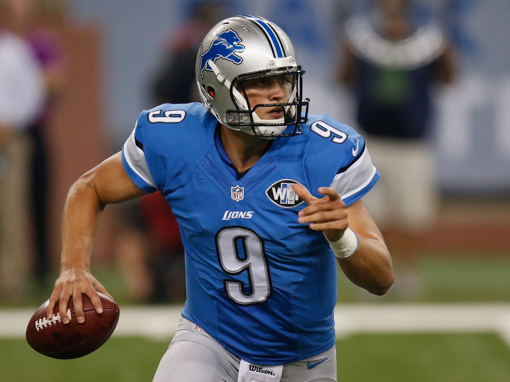 Detroit quarter-back Stafford rushes out of the pocket in search of a receiver