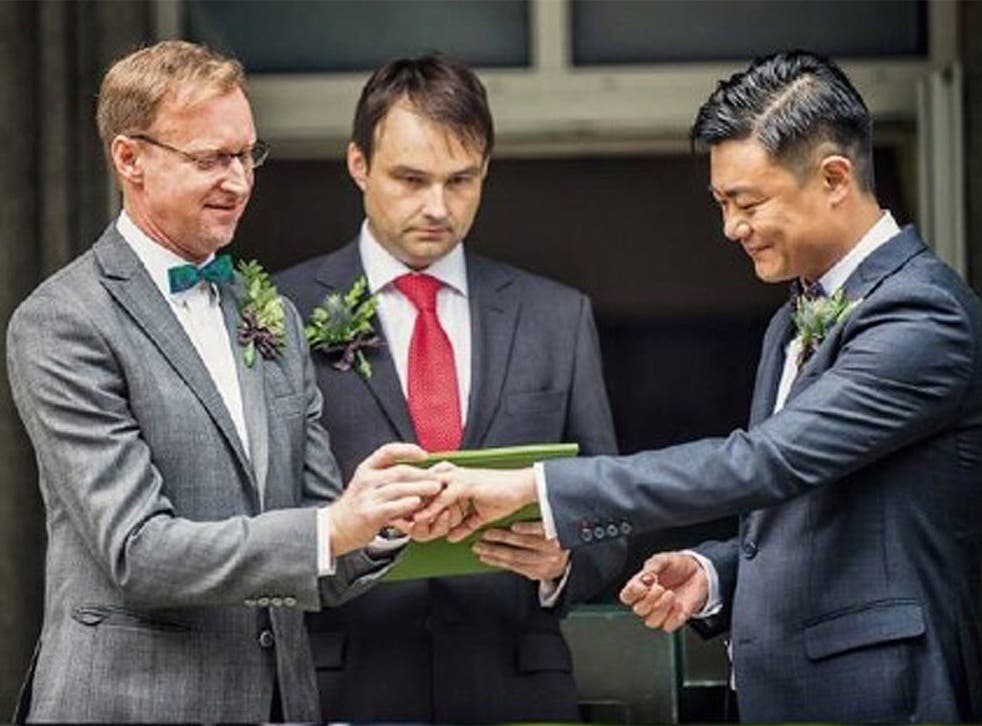 Brian Davidson and his partner Scott Chang exchanging the rings during their wedding ceremony at the British ambassador's residence in Beijing