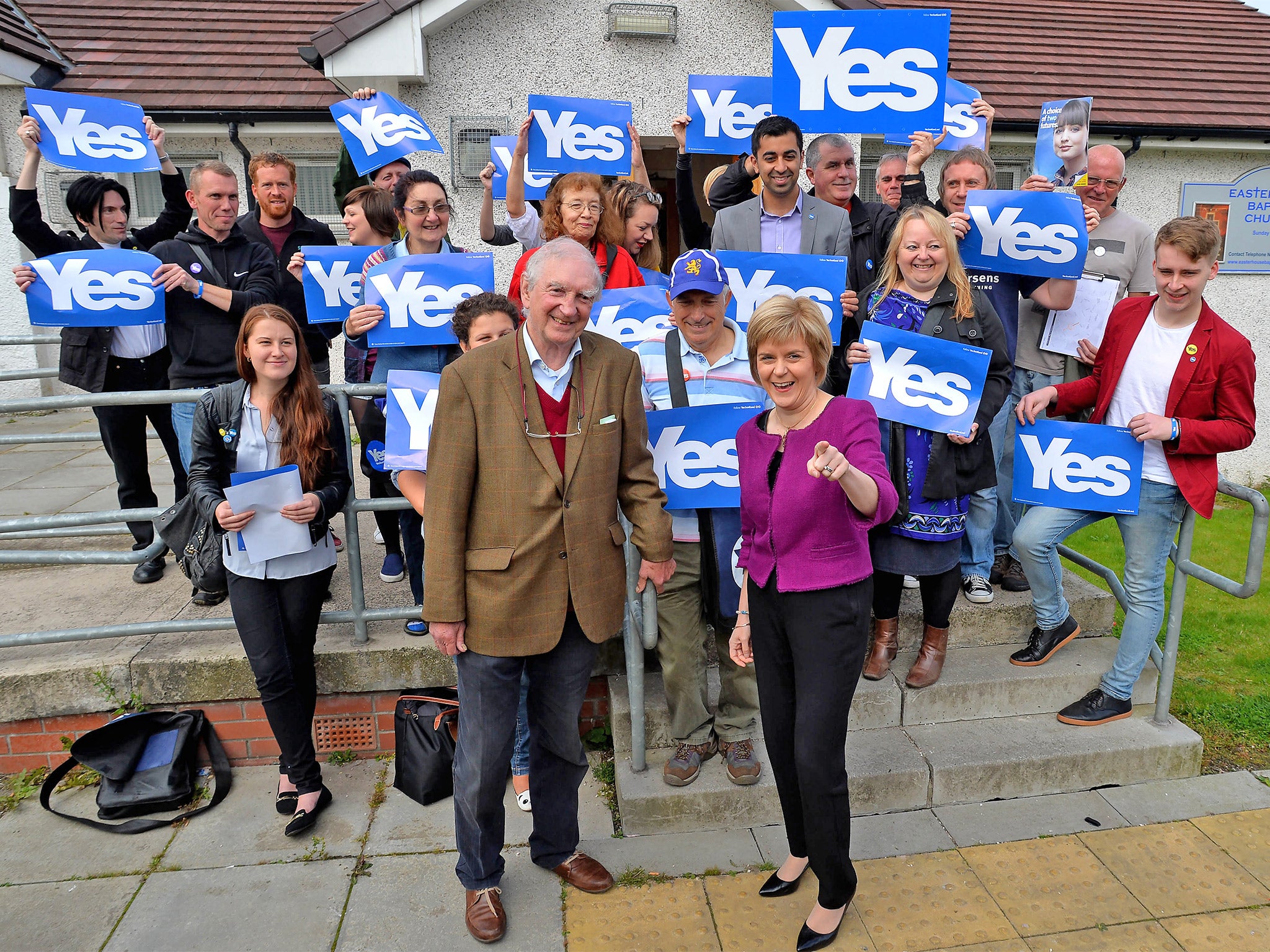 Deputy First Minister Nicola Sturgeon, and anti-poverty campaigner and lifelong Labour Party member Bob Holman pose with 'Yes' campaigners in Easterhouse