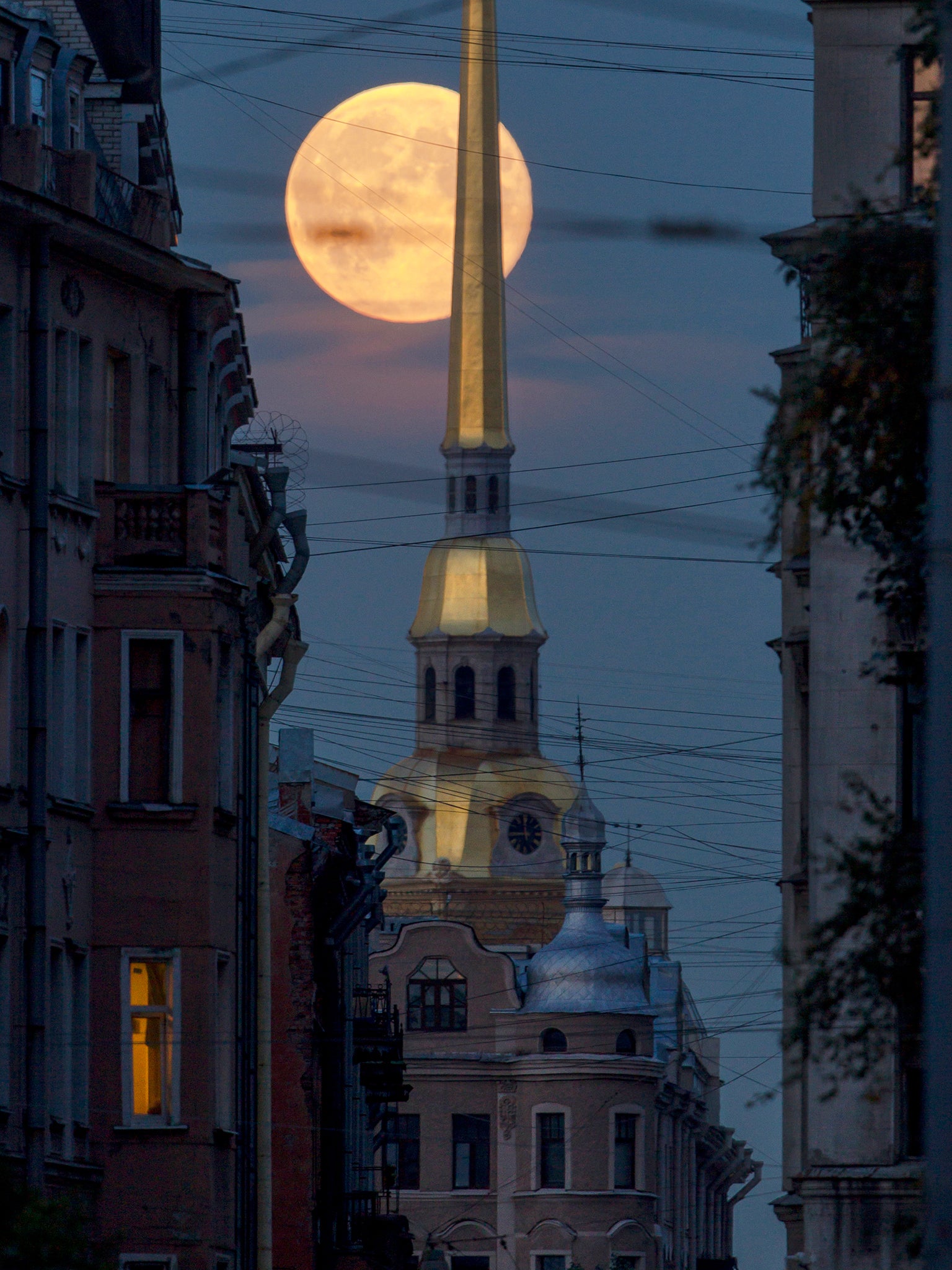 The full moon rises above the St. Peter and St. Paul Cathedral in St. Petersburg