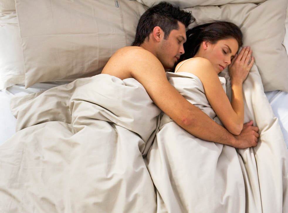 Spooning couple asleep in bed