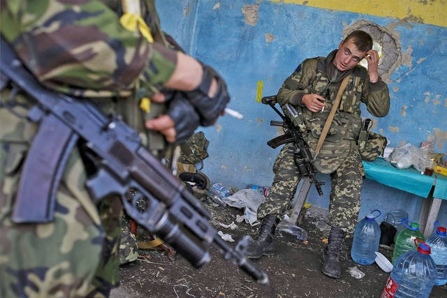 Members of the Ukrainian national guard stand at a checkpoint nearby the town of Slavyanoserbsk, in Luhansk region