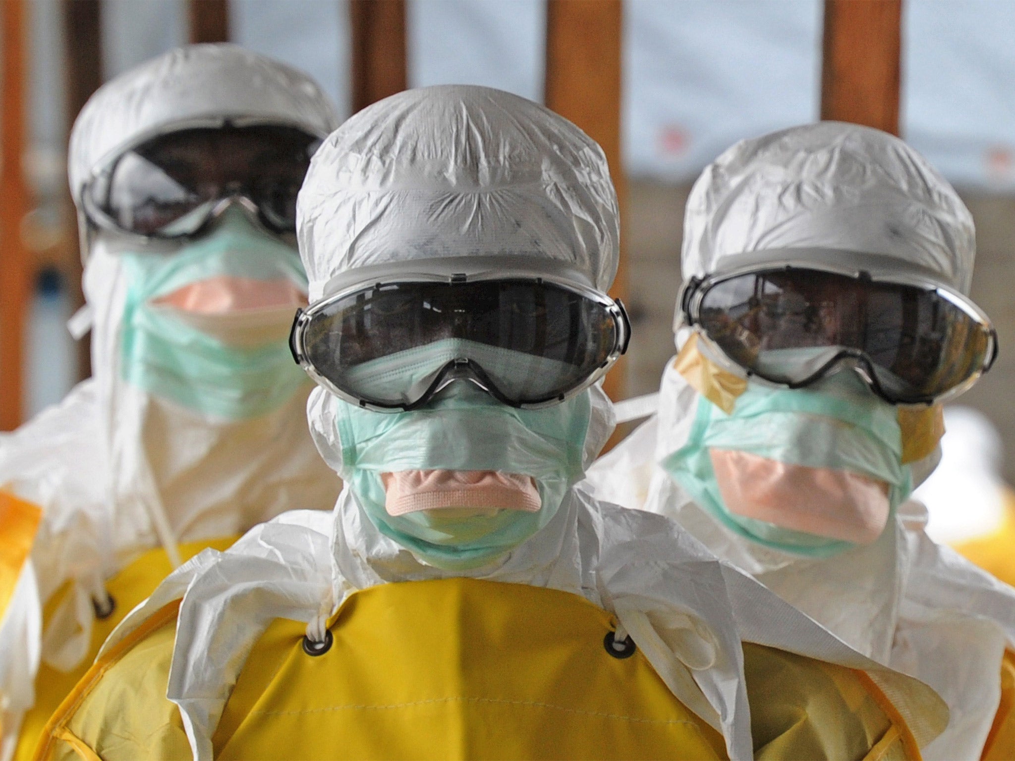 Healthcare workers in Liberia, where the disease has spread, dressed in protective clothing.