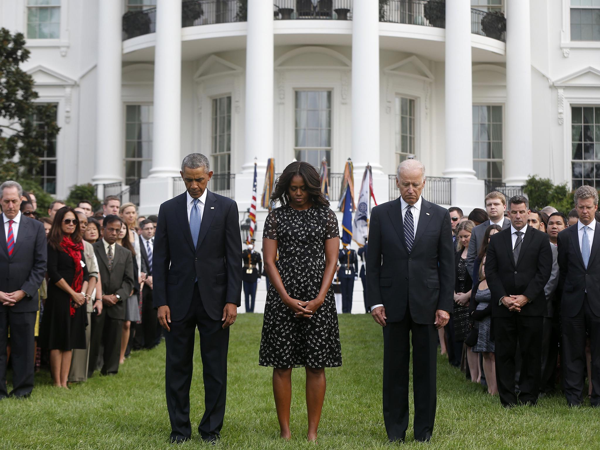 Barack and Michelle Obama and Vice-President Joe Biden observing a moment of silence outside the White House to mark the 13th anniversary of the 9/11 attacks