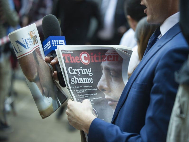 A journalist carrying a selection of South African papers on 12 September