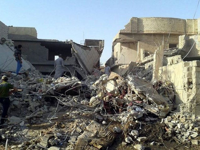 Iraqi men inspect the debris of houses after an air raid by the Iraqi Air Force in Fallujah on 1 September