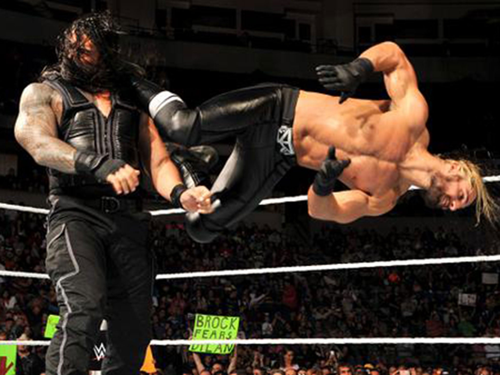 Seth Rollins dropkicks Roman Reigns