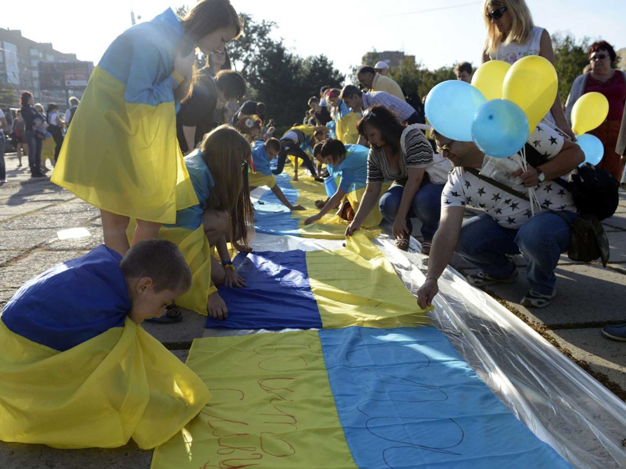 Rally call: Supporters of a united Ukraine sign its flag in Mariupol