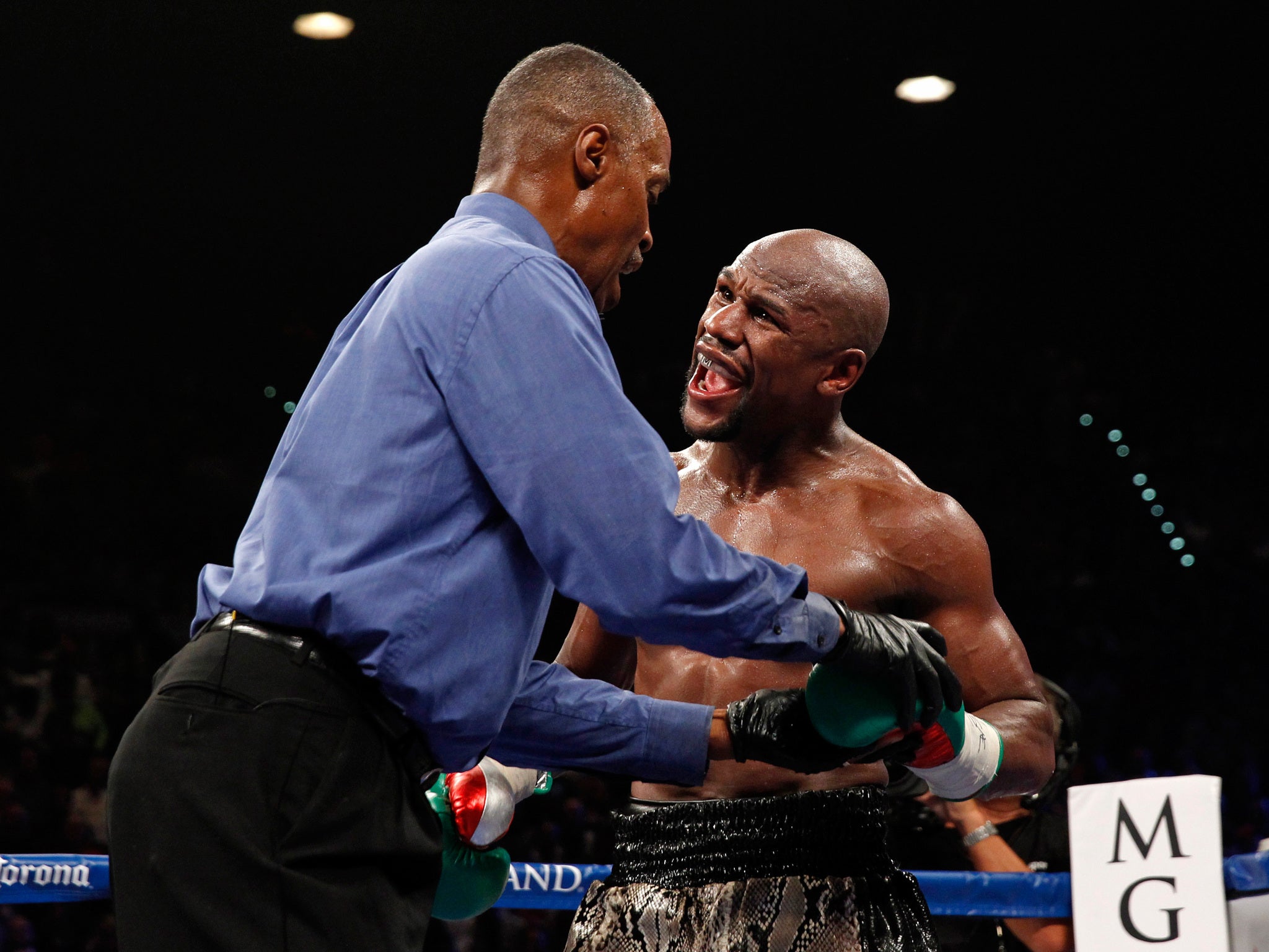 Floyd Mayweather Jr complained that Marcos Maidana bit him as referee Kenny Bayless examines his glove
