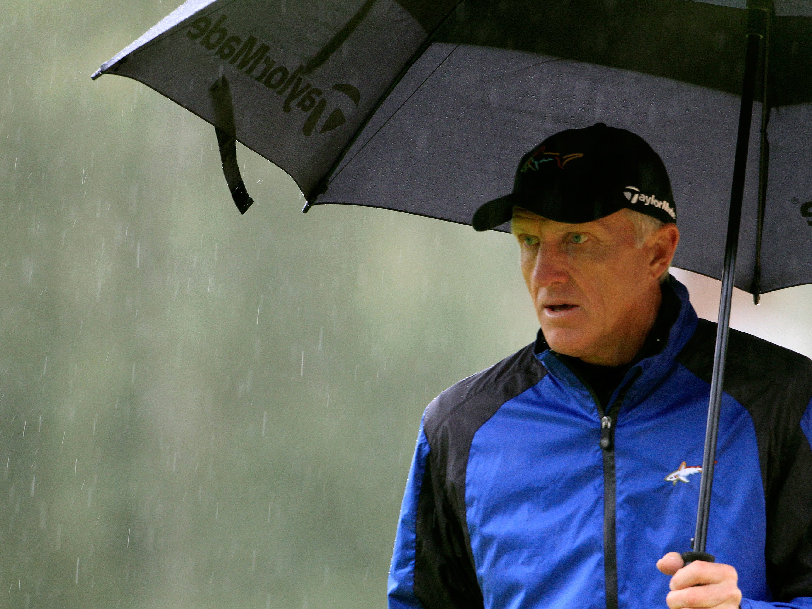 Greg Norman of Australia walks under an umbrella on the 15th green during the second round of the European Masters golf tournament in the Swiss mountain resort of Crans-Montana in August 2012