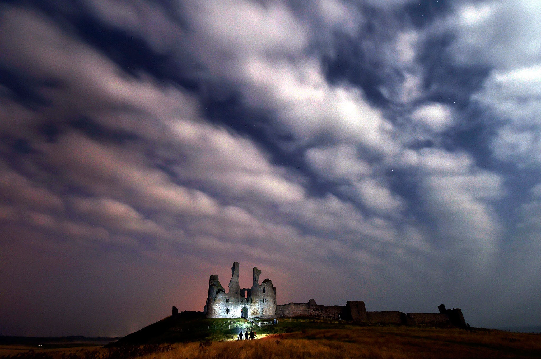 Clouds roll in over Dunstanburgh Castle in Northumberland, as photographers await the much anticipated northern lights