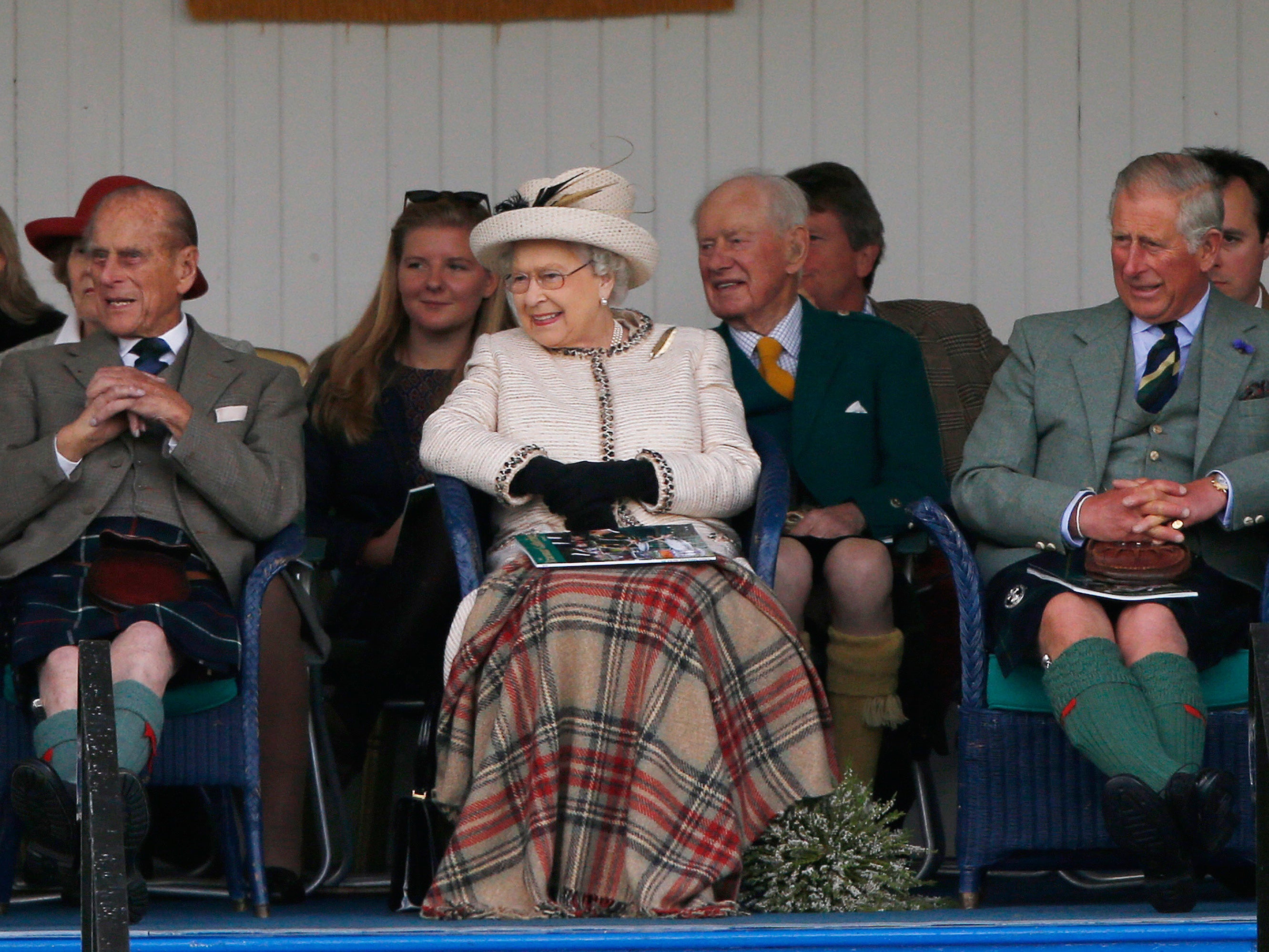 The Queen watches the caber being tossed at the annual Braemar Highland Gathering in Braemar, Scotland, with Prince Philip and Prince Charles, earlier in September