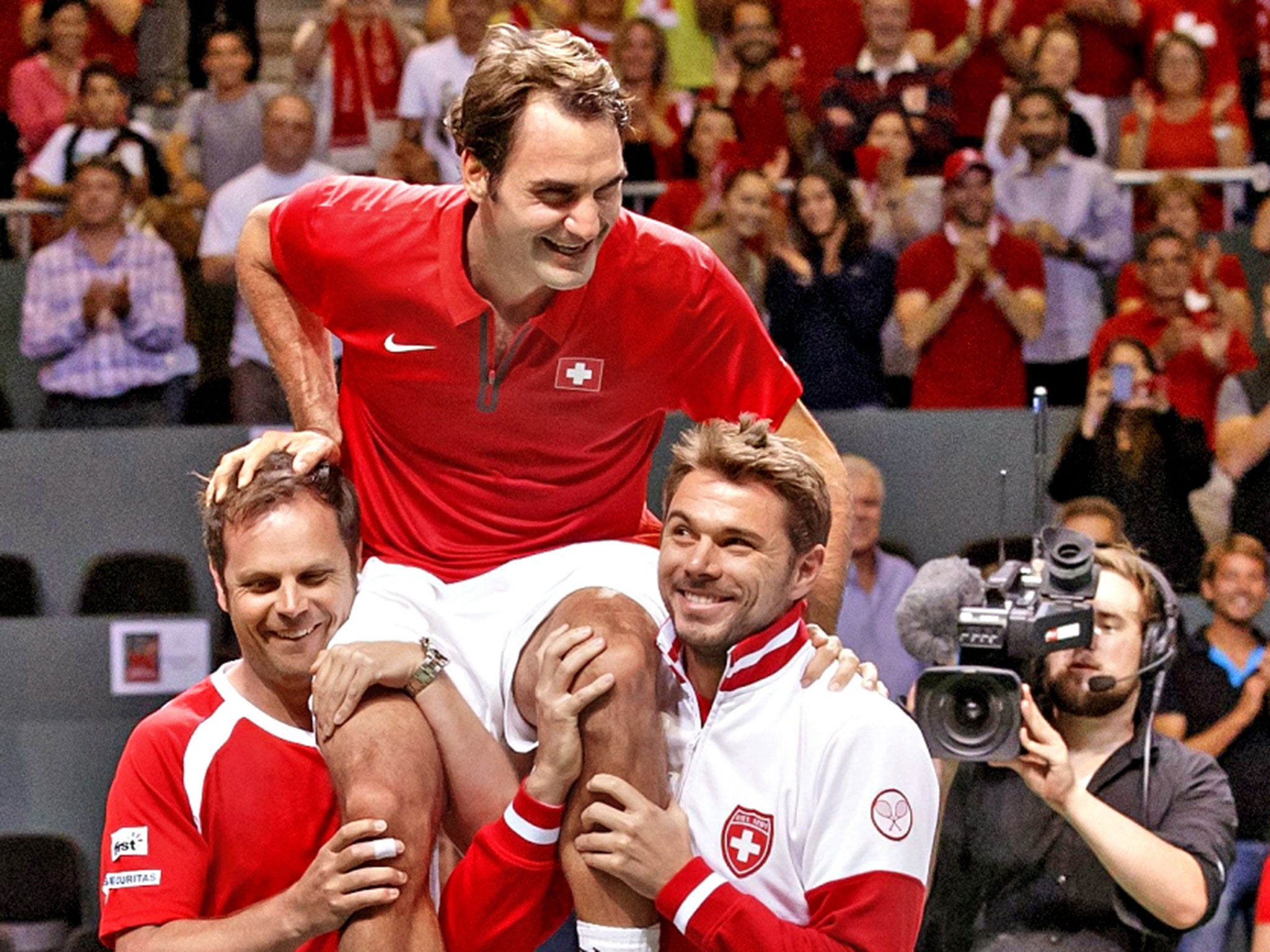 Roger Federer celebrates with Swiss Davis Cup captain Severin Luthi (left) and Stanislas Wawrinka