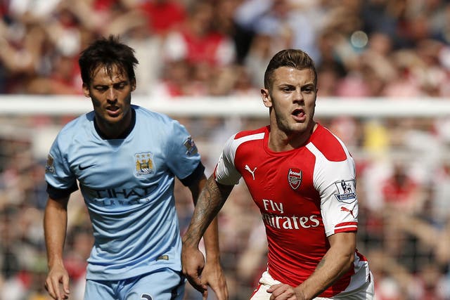Jack Wilshere, right, makes a break watched by David Silva