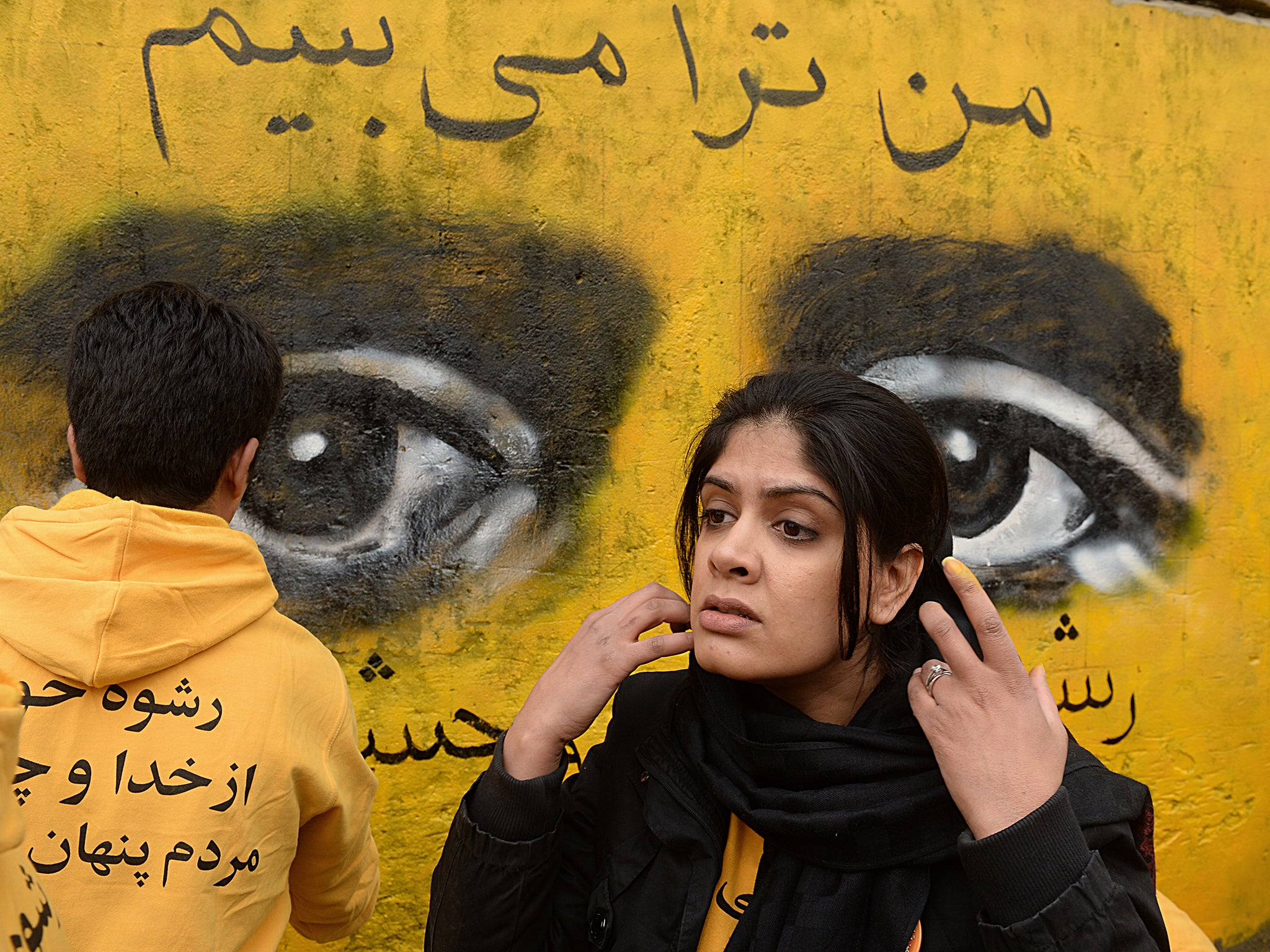 Shamsia Hassani (26) works on a street mural during an event to mark International Women's Day in Kabul