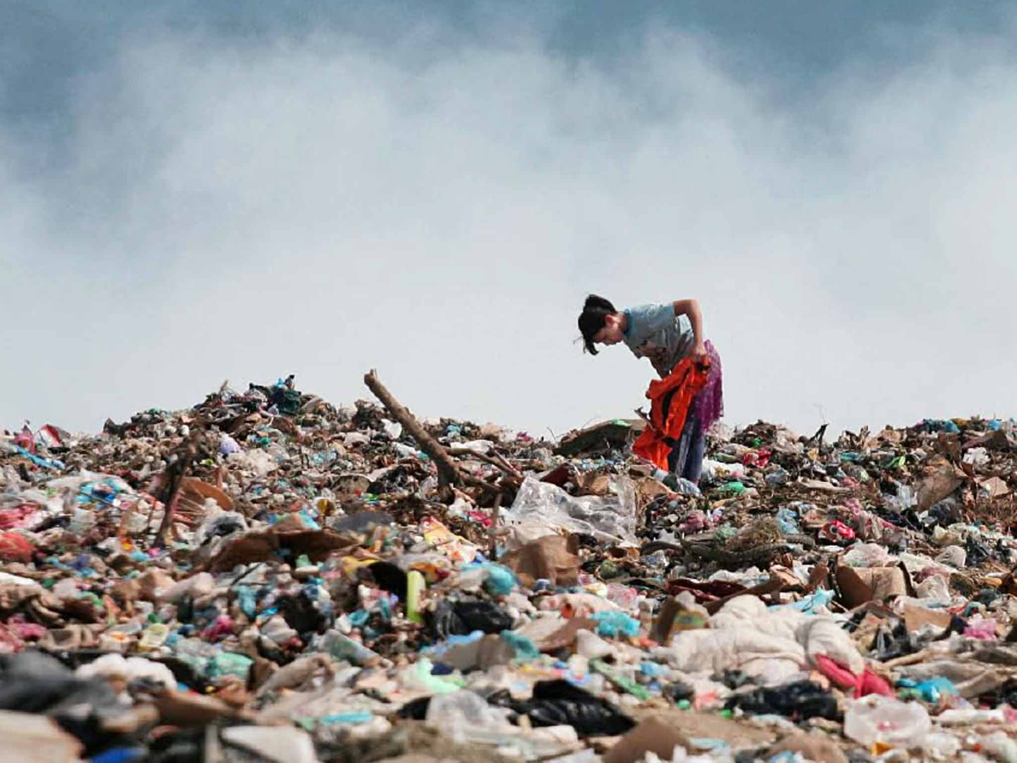 A young rubbish-picker sifts through the refuse