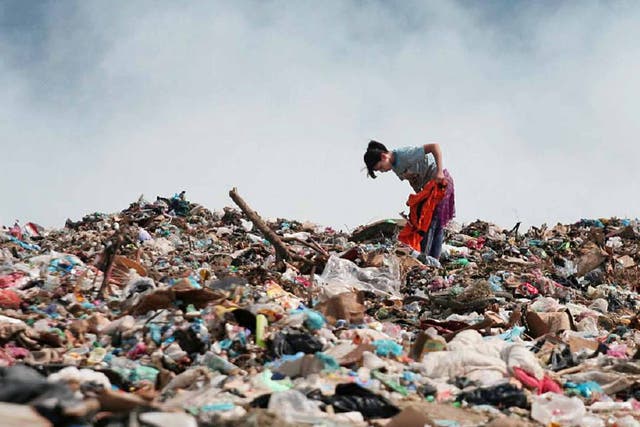 A young rubbish-picker sifts through the refuse