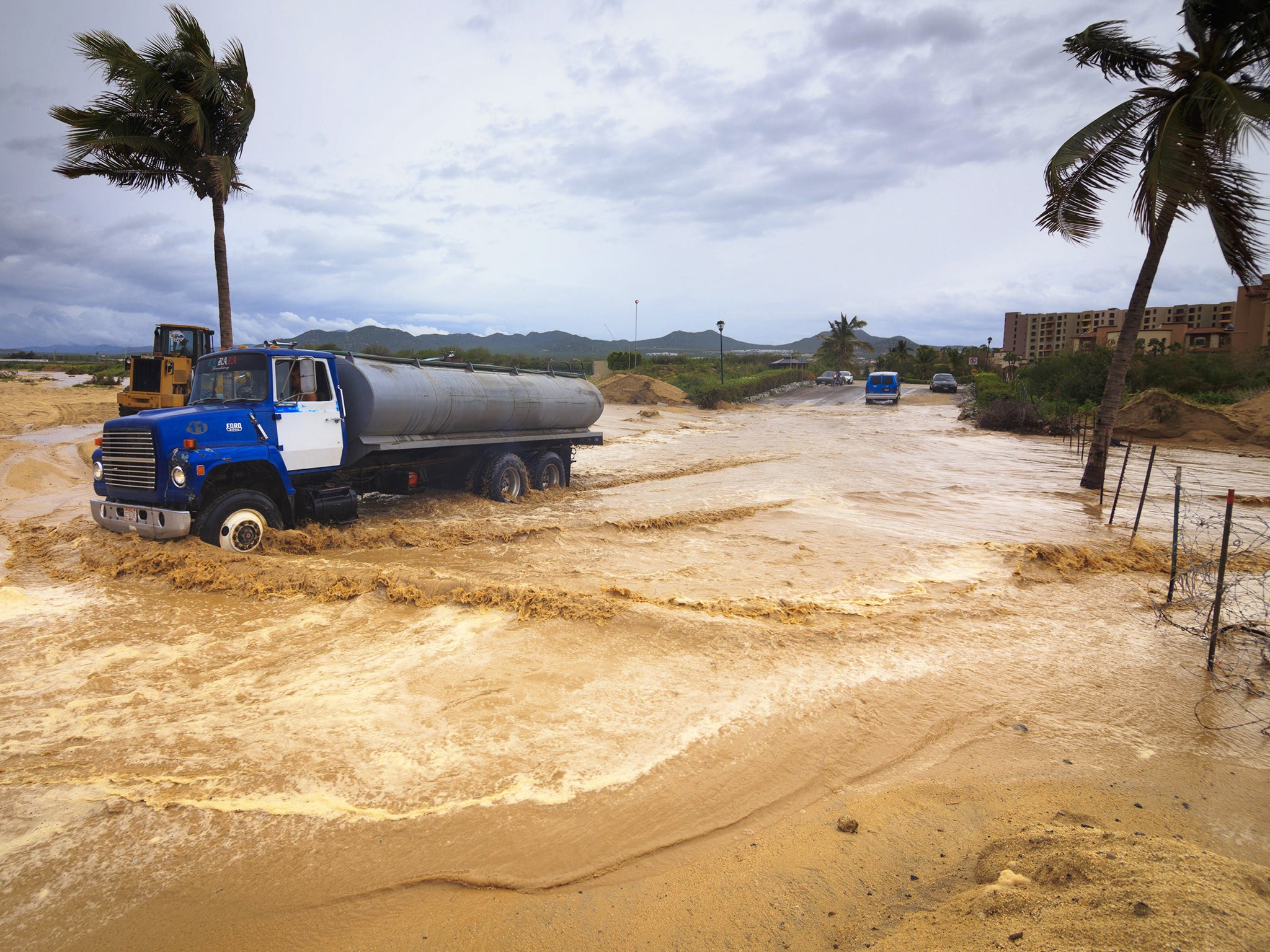 A vehicle transits a flooded street due to the influence of hurricane Odile in Los Cabos